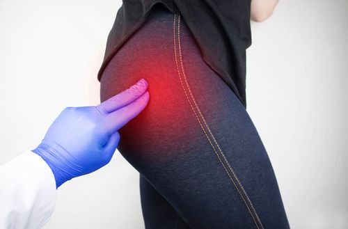 Image is of a doctor assessing patient's sciatica pain, concept of sciatica treatment in Chicago
