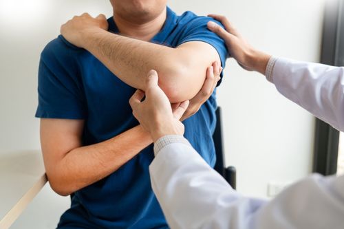 Image is of a male patient with a physical therapist concept of shoulder pain treatment in Chicago