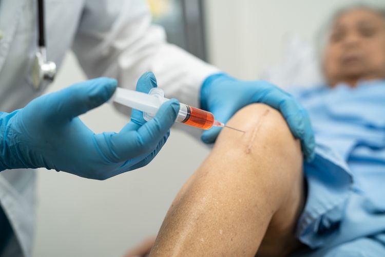 doctor administering injections to treat pain in a patients knee
