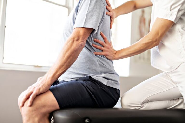 Image is of a male patients and a physical therapist performing exercises, concept of physical therapy managing sciatica pain