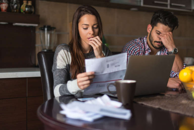 Image is of a stressed man and woman looking at medical bills after a personal injury accident.
