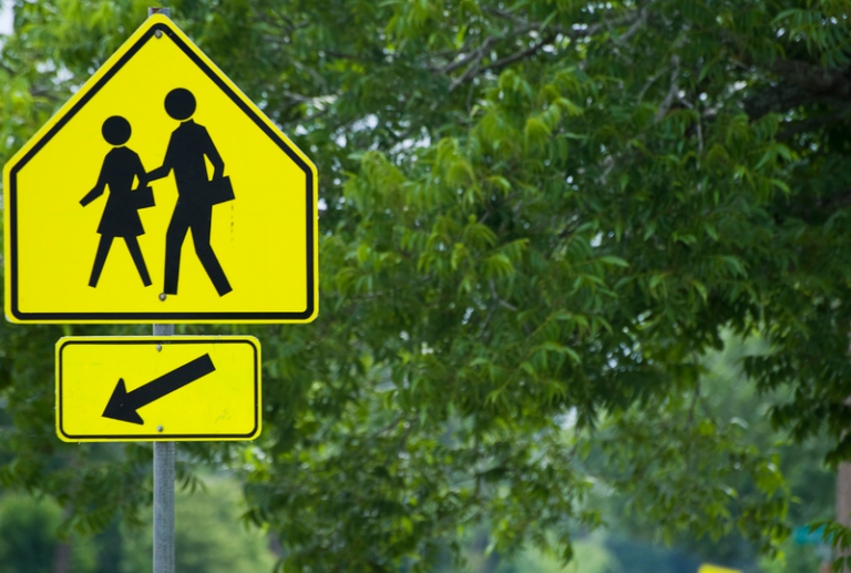 Image is of a yellow pedestrian crossing street sign, concept of common pedestrian accident injuries