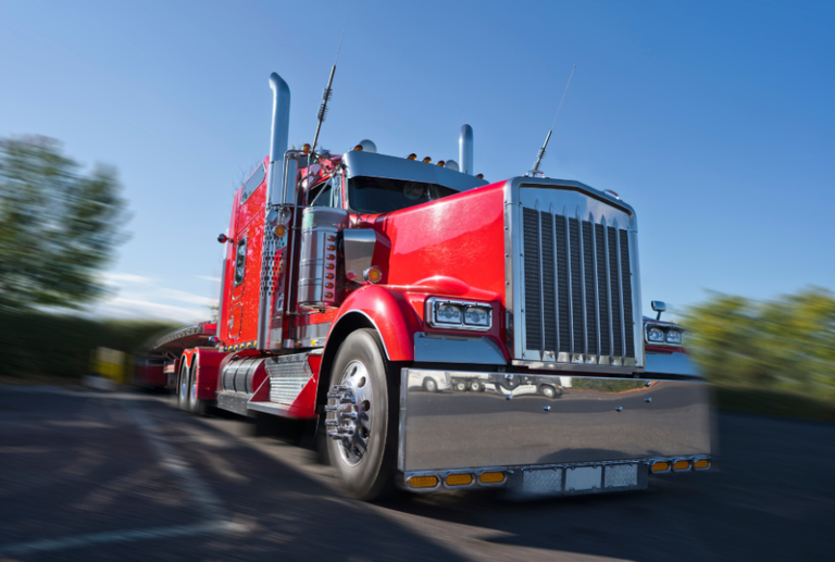 Image is of a close up front end view of a semi truck, concept of truck accident injury treatment