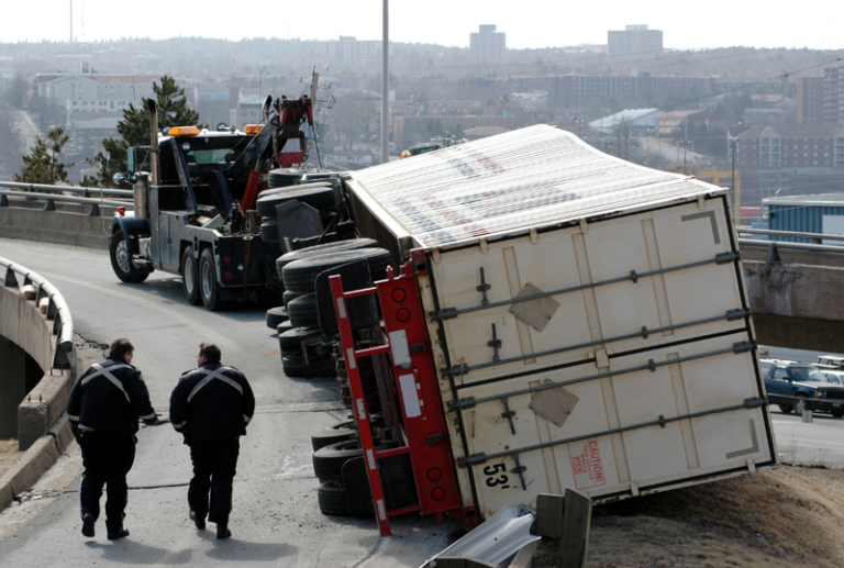 Image is of a semi-truck on its side, following an accident, concept of severe truck accident injuries