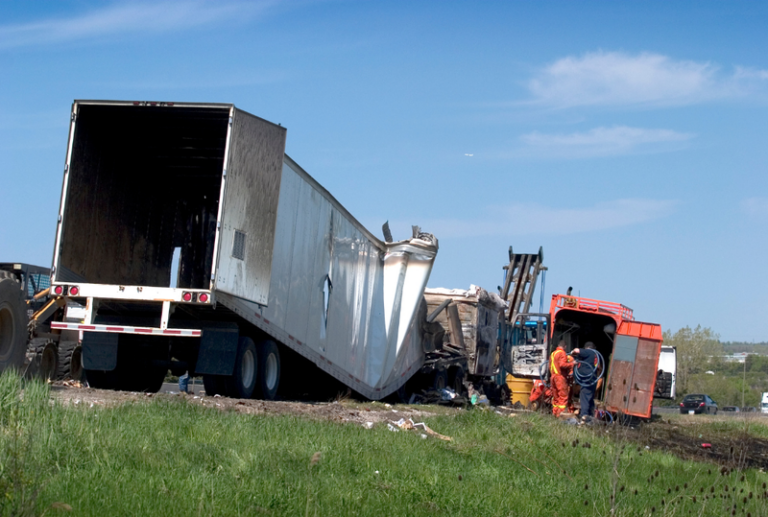 Image is of a crashed semi truck concept of the common injuries from truck accident injuries